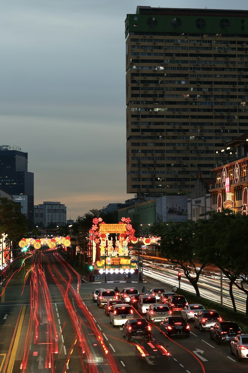 a city street filled with lots of traffic next to tall buildings