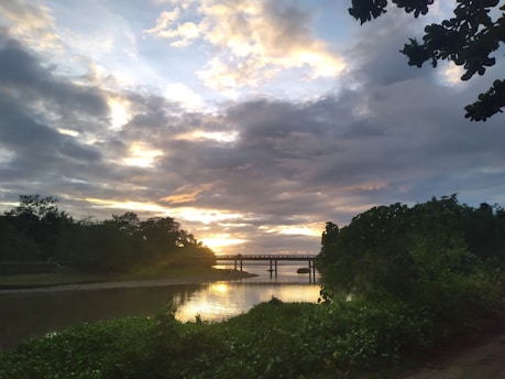 A serene landscape featuring a sunset over a tranquil river, symbolizing the fusion of tradition and modernity.