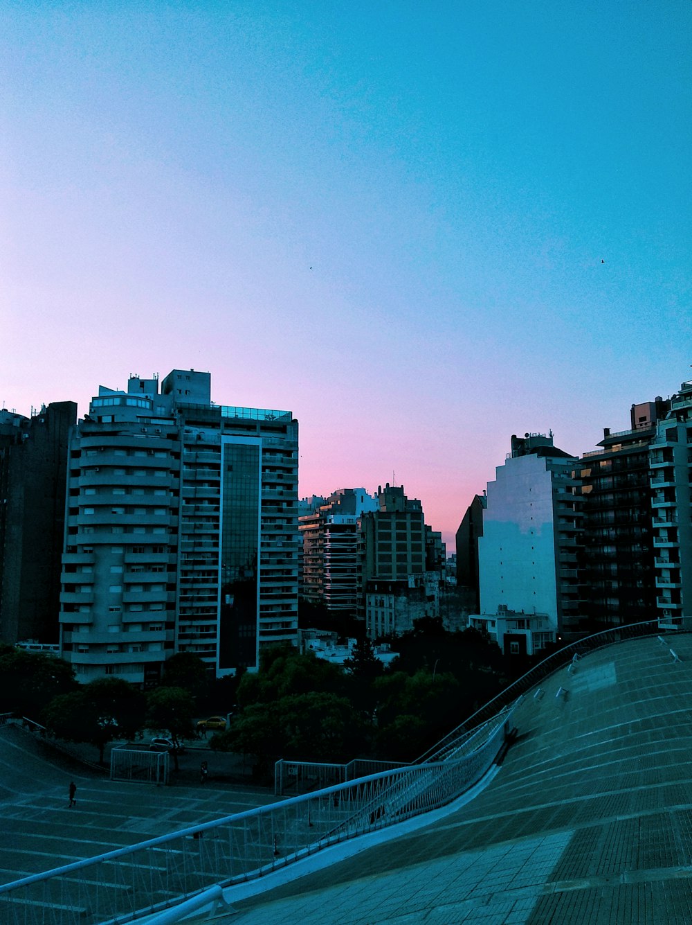 a skateboarder doing a trick in front of a city skyline