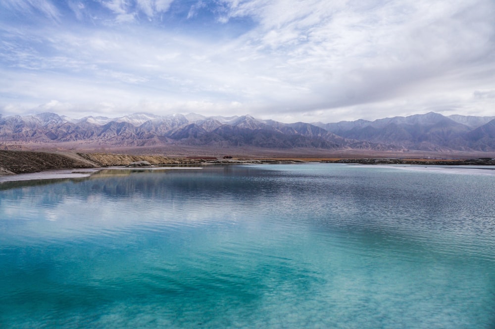 a body of water with mountains in the background