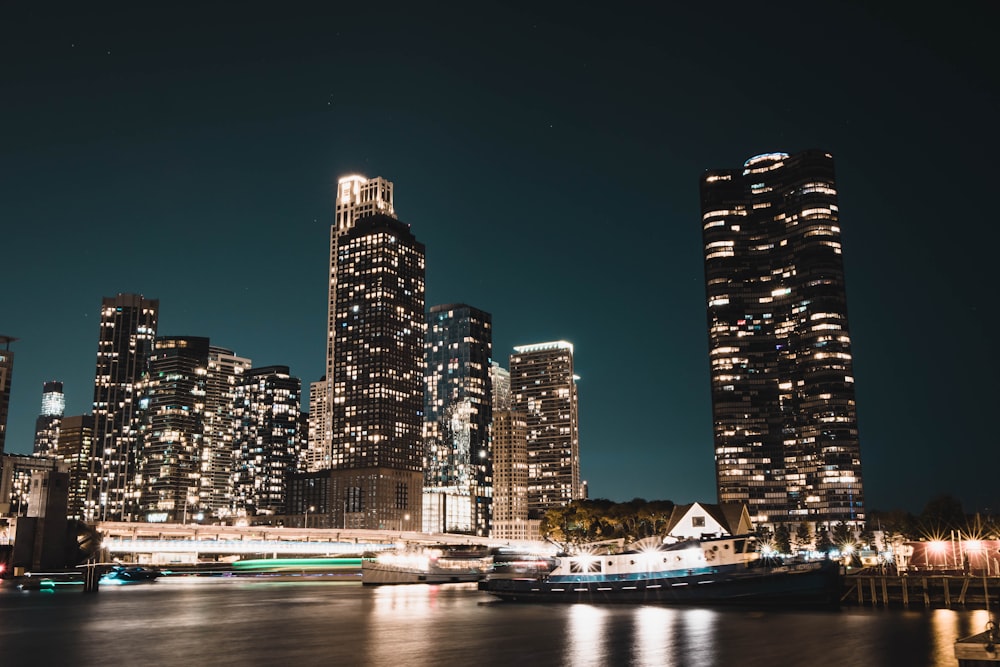 a city skyline at night with a boat in the water