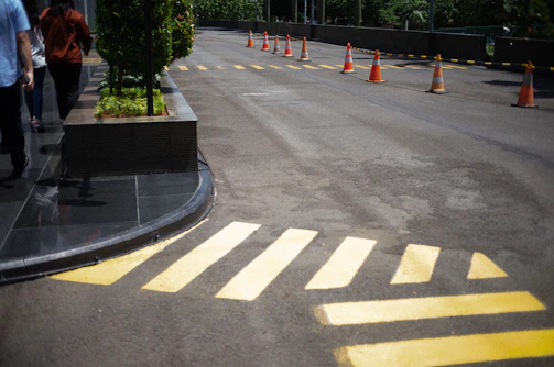 Finished sidewalk with fresh asphalt and pedestrian signs in a city center.