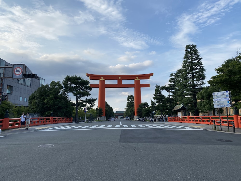 a large orange gate in the middle of a street
