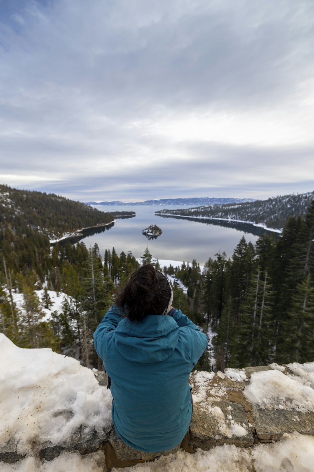 a person sitting on top of a snow covered hill