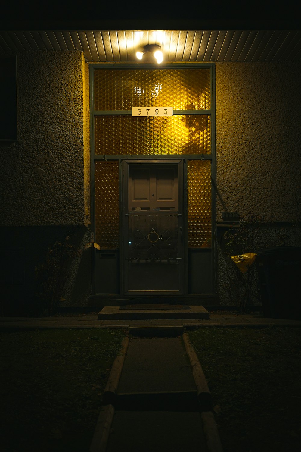 a door is lit up at night in front of a house