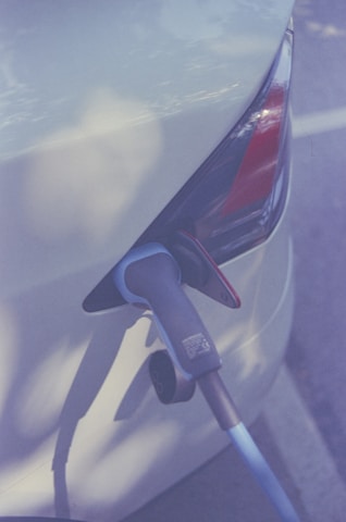 Close-up of a shiny Aion electric car charging at a station.