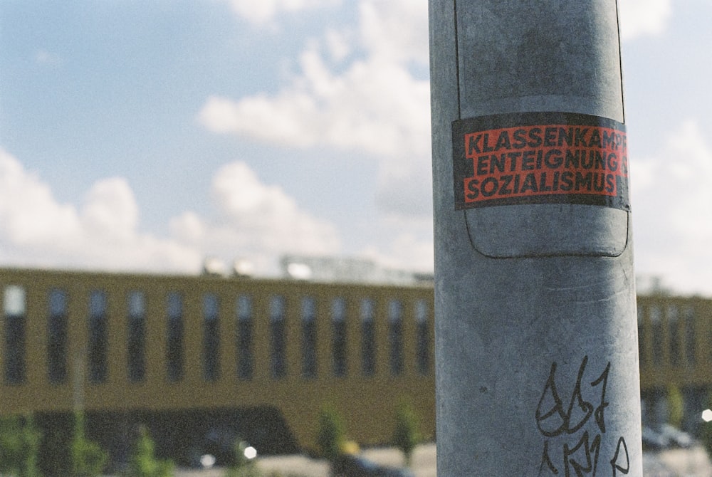 a pole with a sticker on it in front of a building