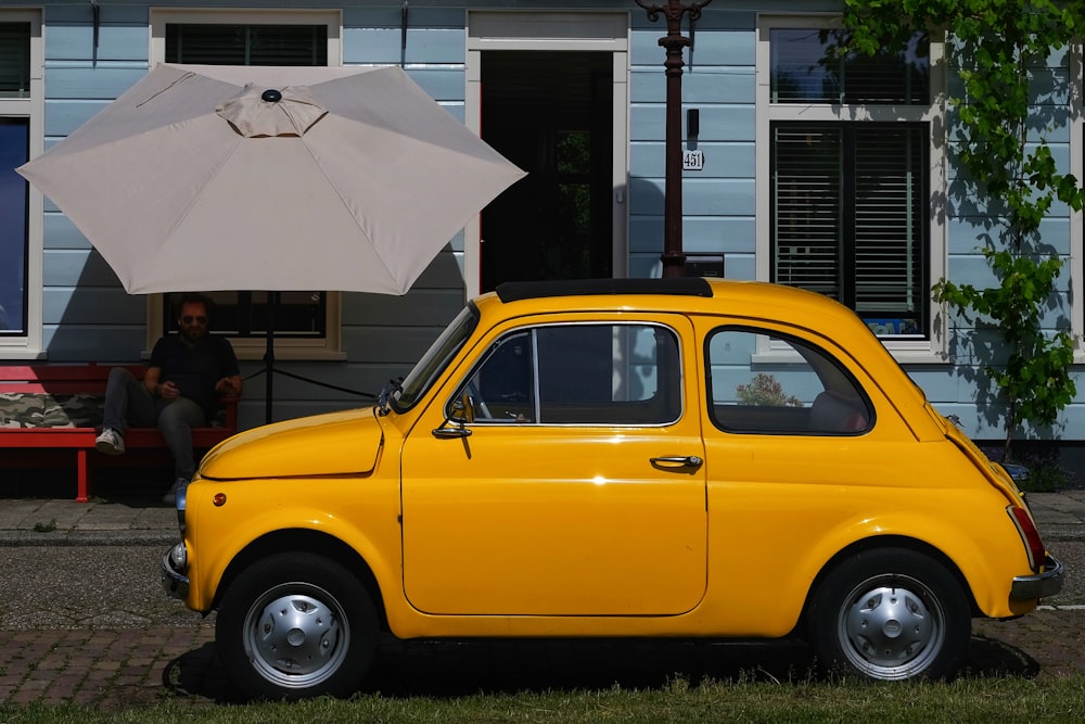 a small yellow car parked in front of a house