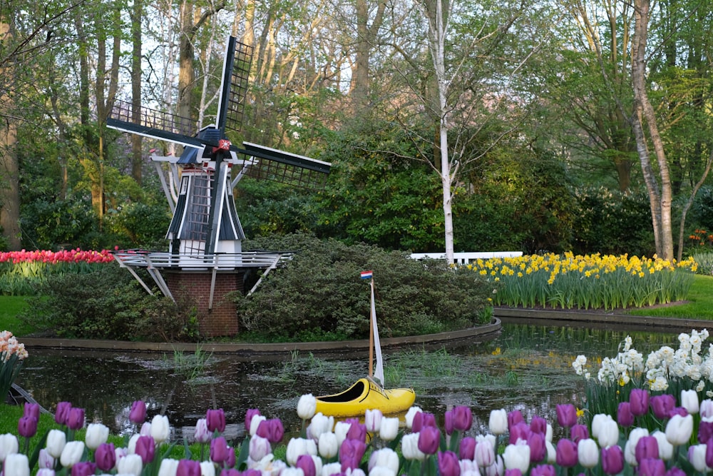 a windmill in the middle of a field of flowers