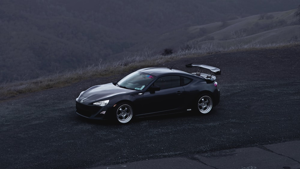 a black sports car parked on the side of a road