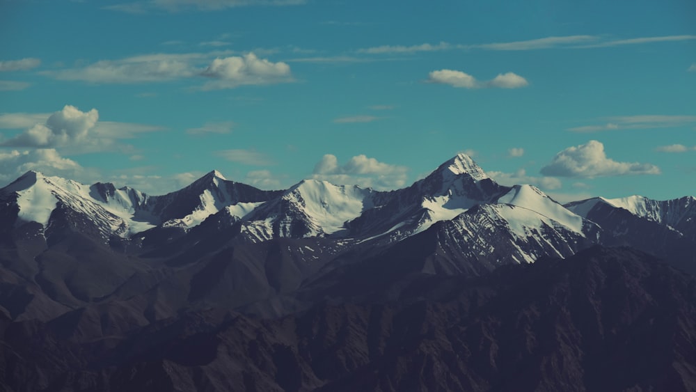 a mountain range with snow capped mountains in the distance