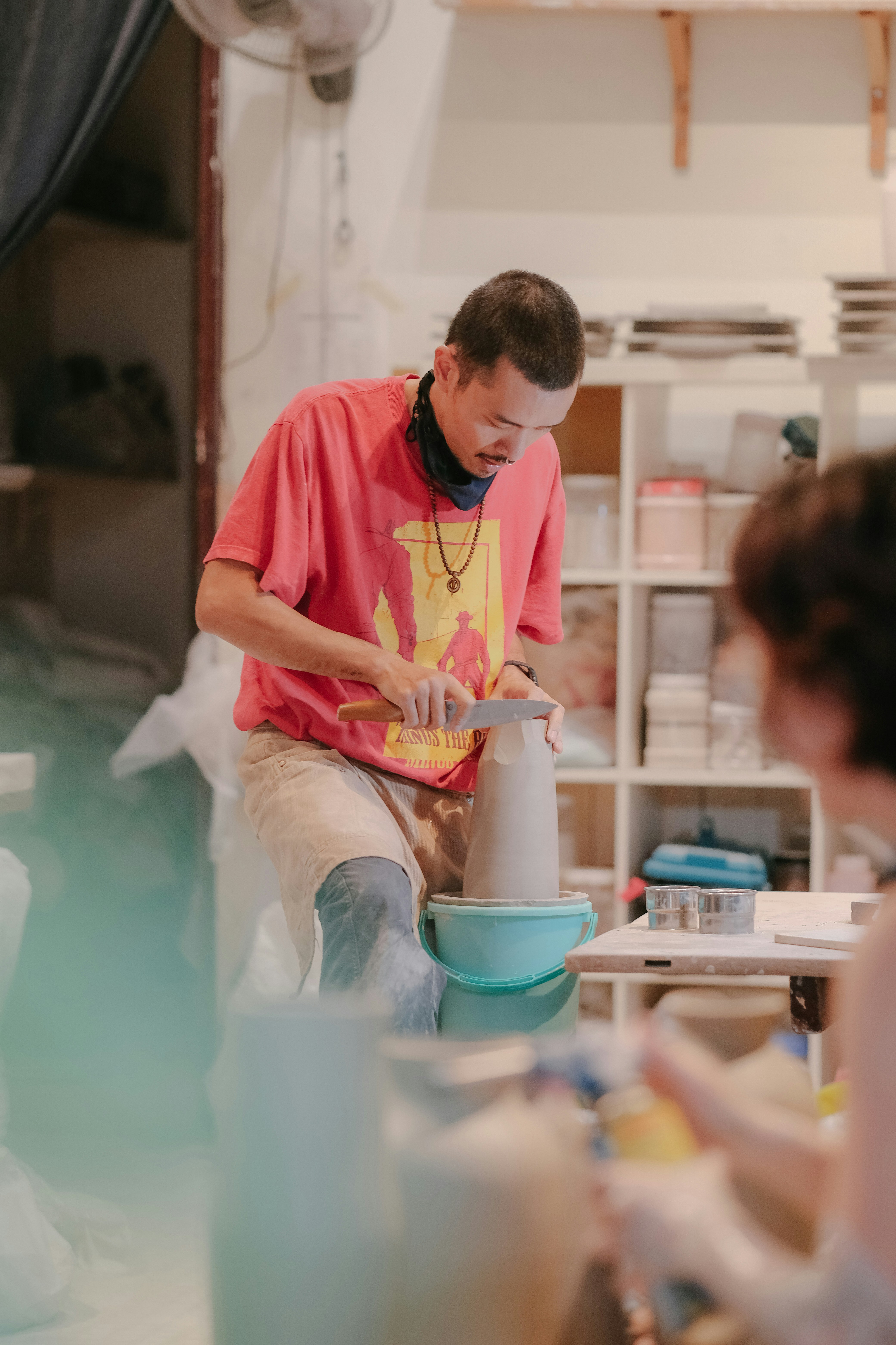 a man is making a vase in a studio