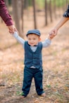 a little boy holding the hand of a woman's hand
