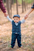 a little boy holding the hand of a woman's hand