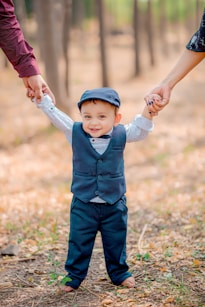 a little boy holding the hand of a woman's hand