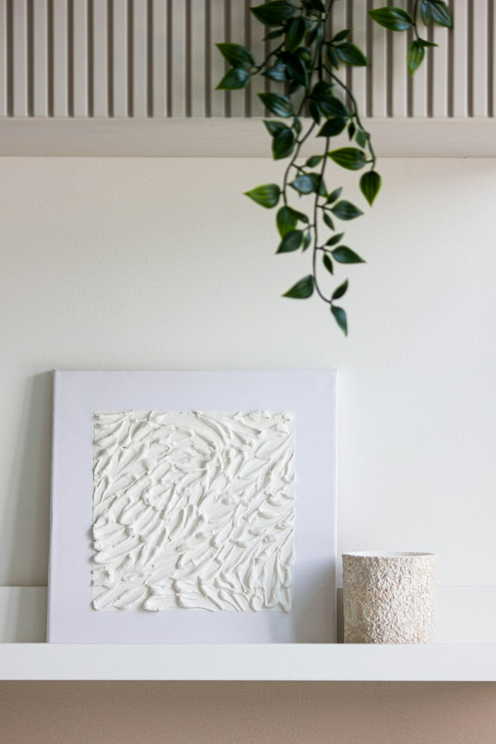 a white picture frame sitting on top of a shelf