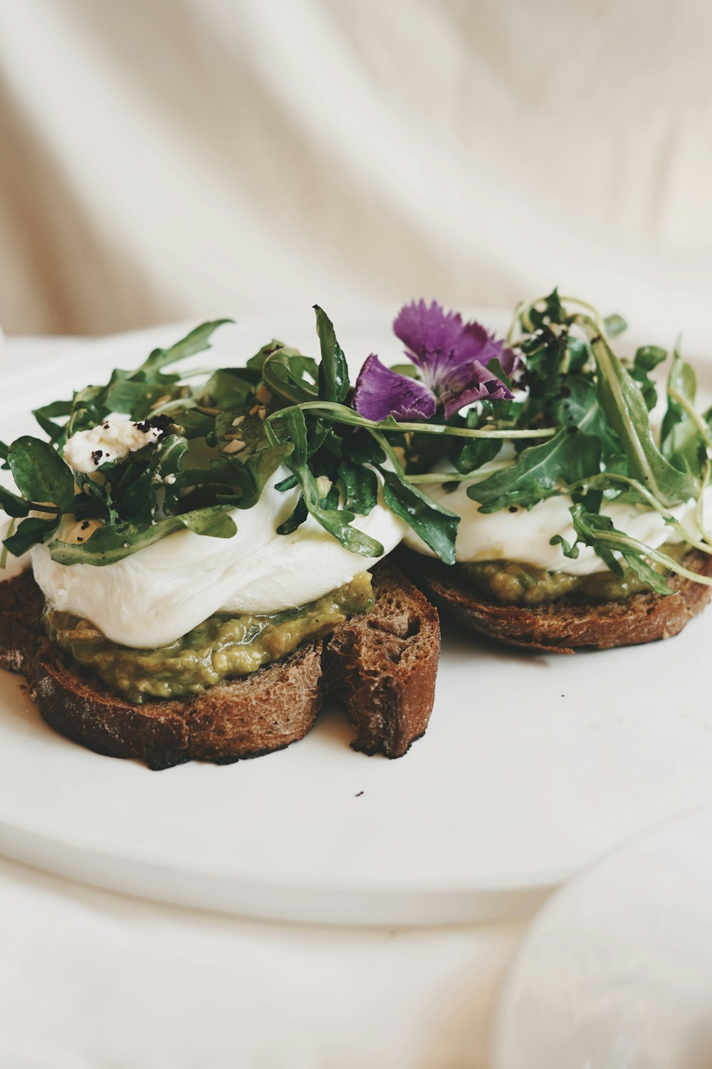 a white plate topped with two open faced sandwiches