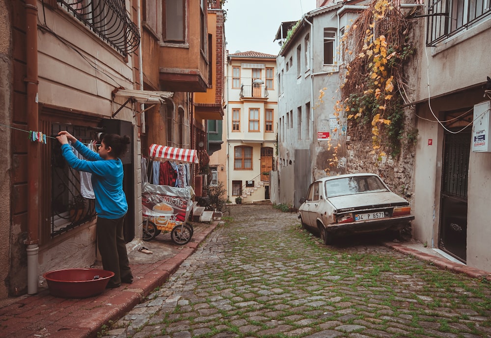 a man taking a picture of a car in a narrow alleyway