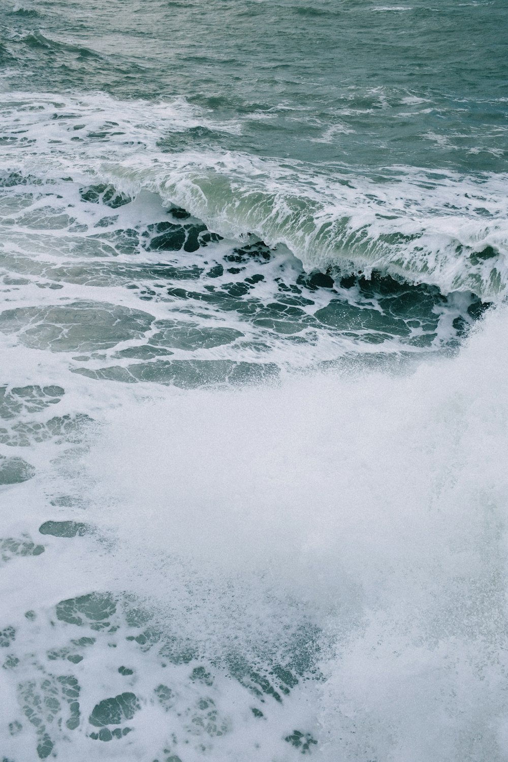 a man riding a surfboard on top of a wave in the ocean