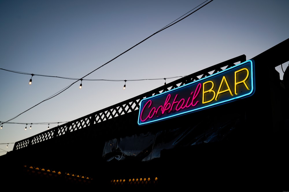 a neon sign for a bar that is lit up