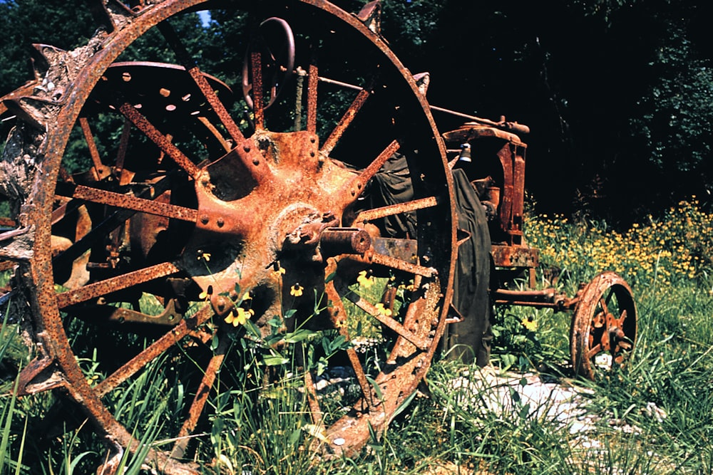 an old rusted wheel sits in the grass