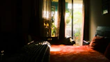 Serene family room with warm saffron accents and comfortable bedding overlooking peaceful ashram gardens.