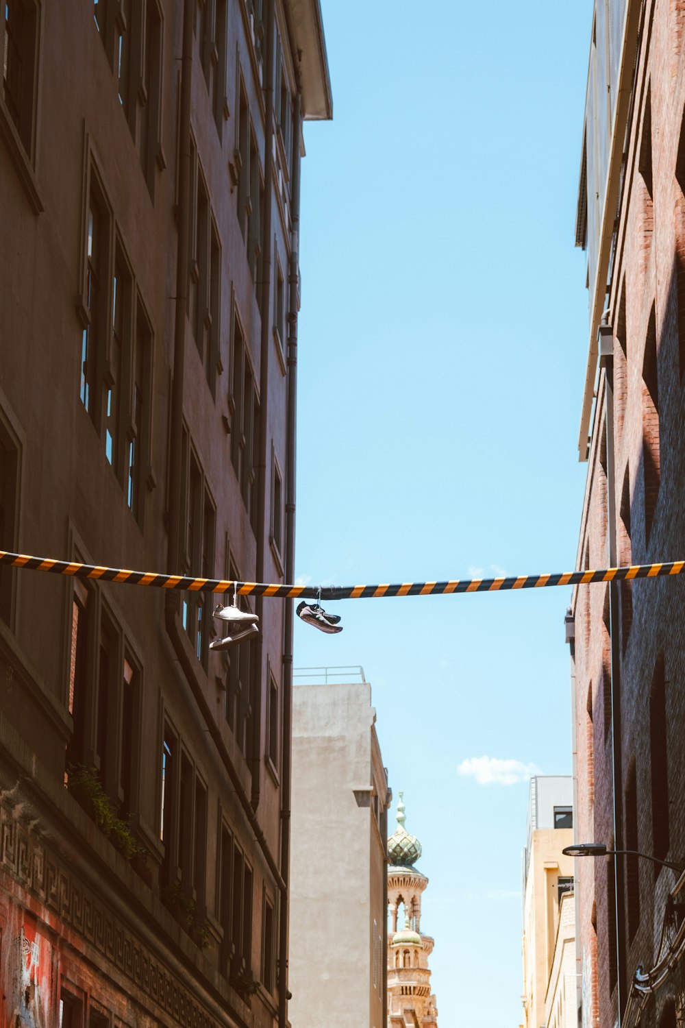 a couple of people walking down a street next to tall buildings