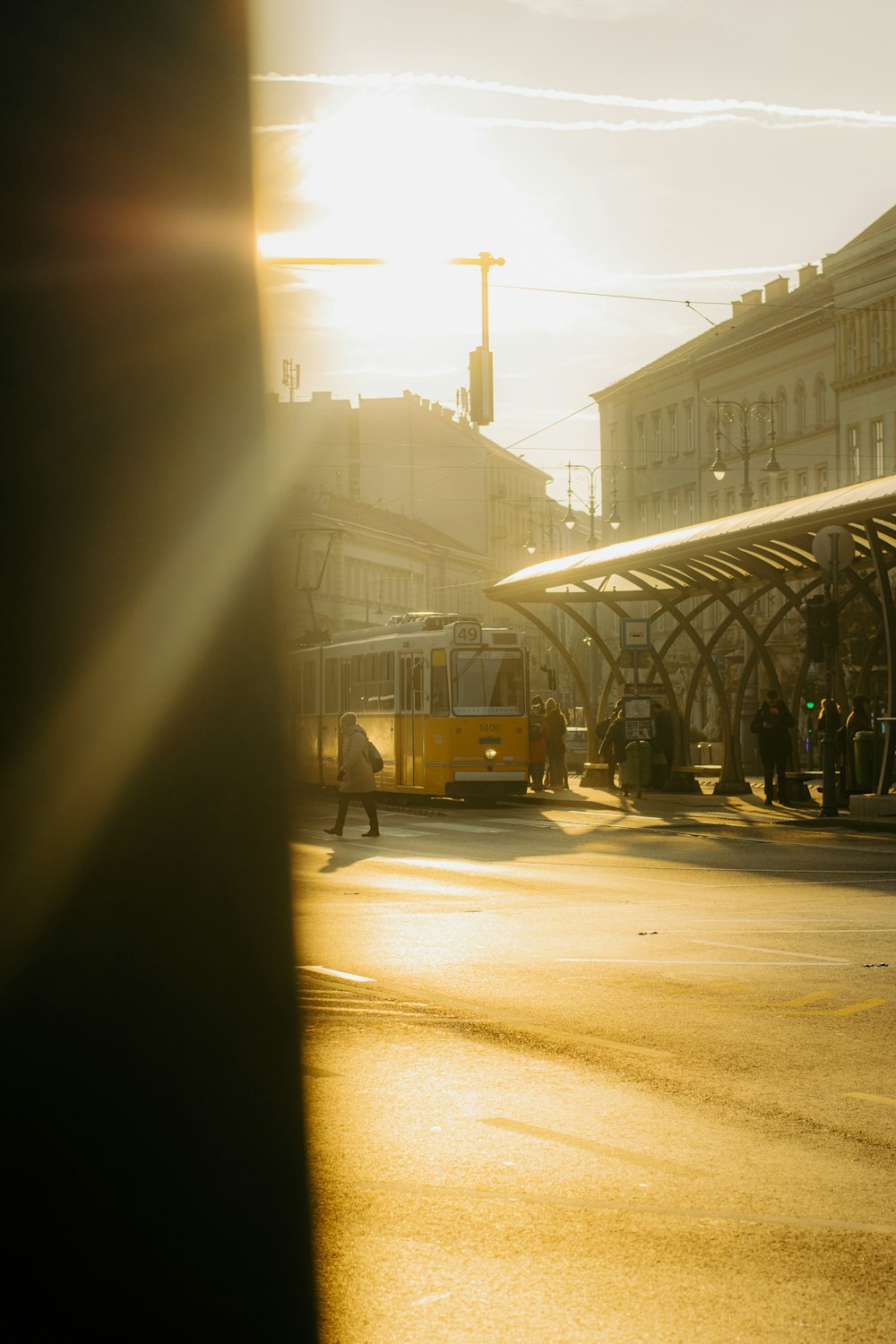 a yellow bus driving down a street next to tall buildings