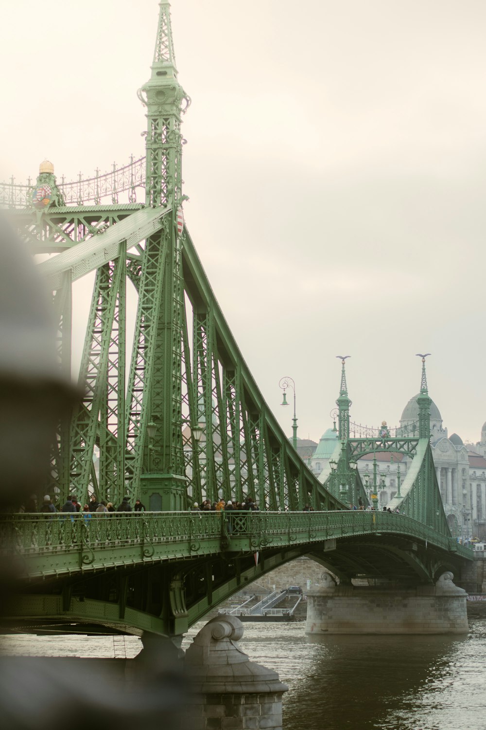 a bridge over a body of water with buildings in the background