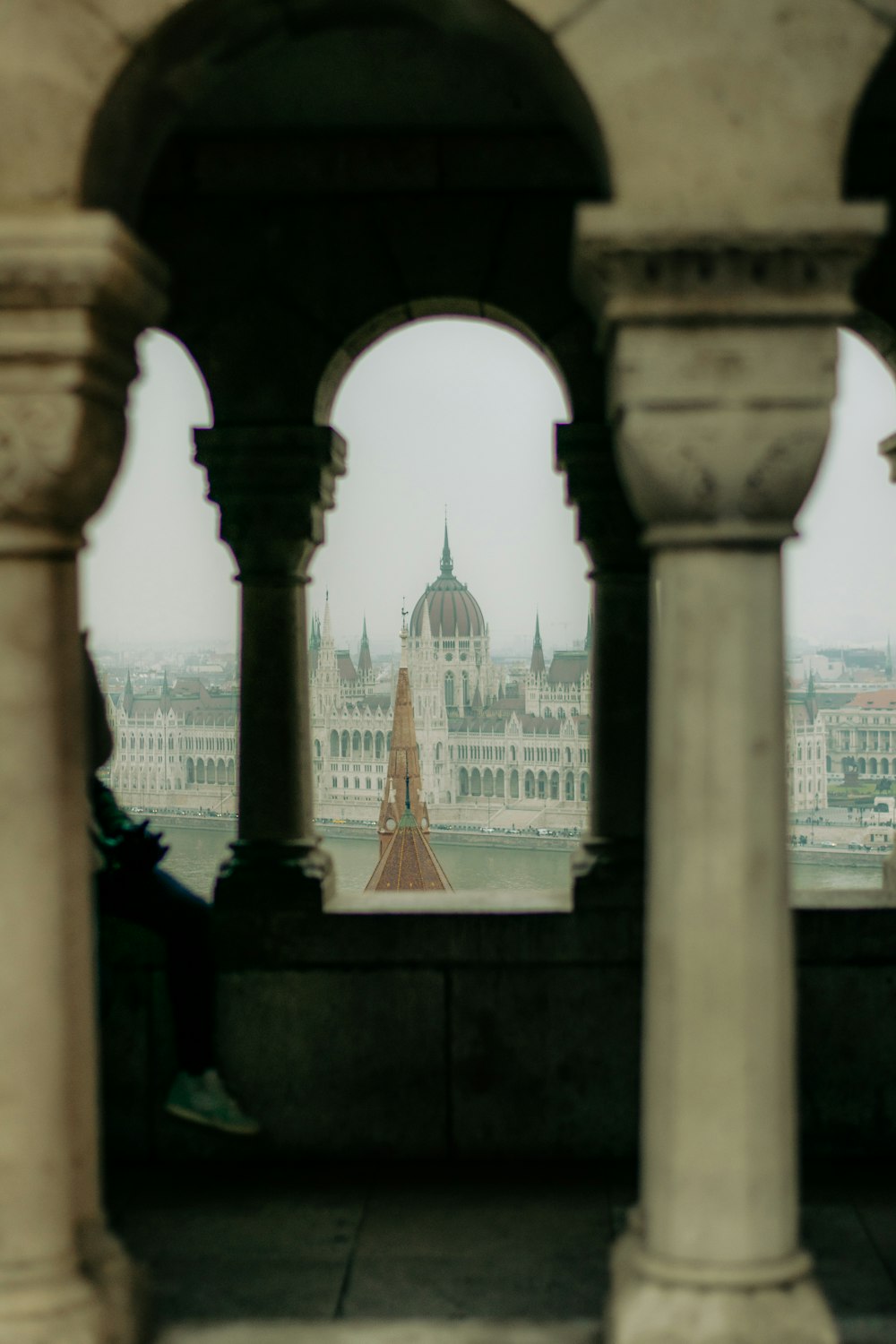 a view of a large building through some pillars