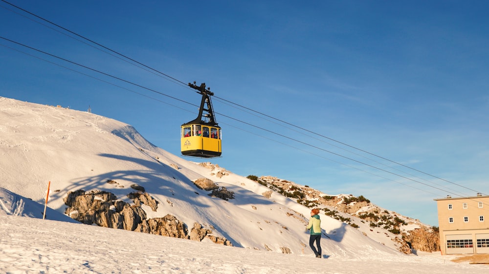 a person standing in the snow under a ski lift