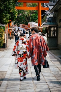 Two tour guides leading a group through a traditional Japanese street in autumn.