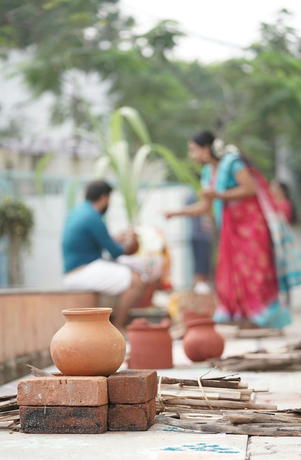 a couple of people that are standing around a vase