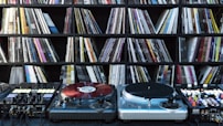 Close-up of vintage vinyl records stacked beside modern digital music equipment, symbolizing dj nijgman’s evolution.
