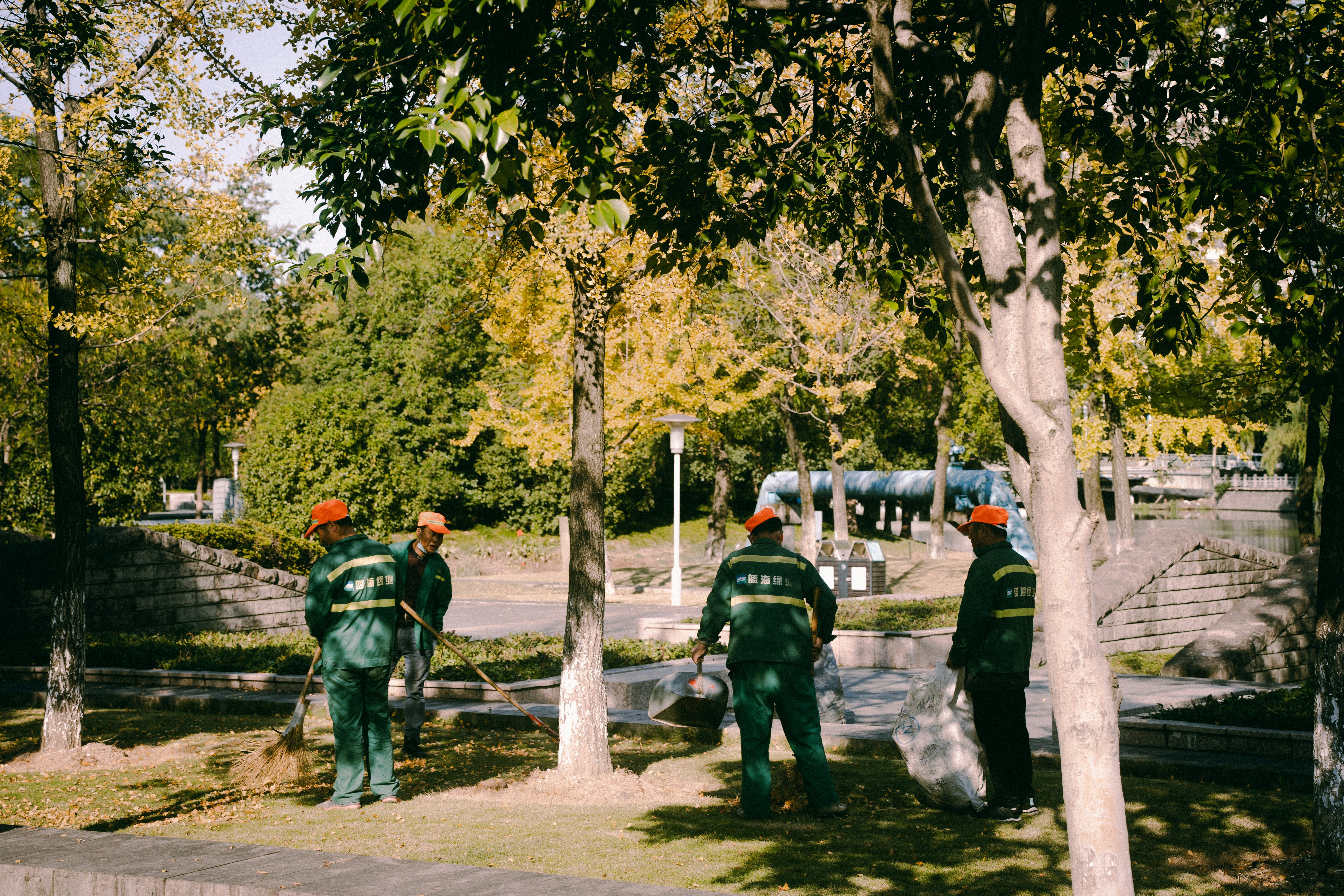 Cleaning staff in uniform attentively sanitizing park benches and common areas outdoors.