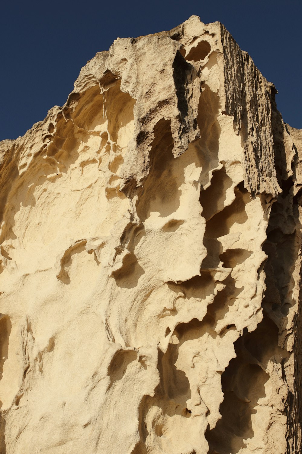 a large rock formation with a blue sky in the background