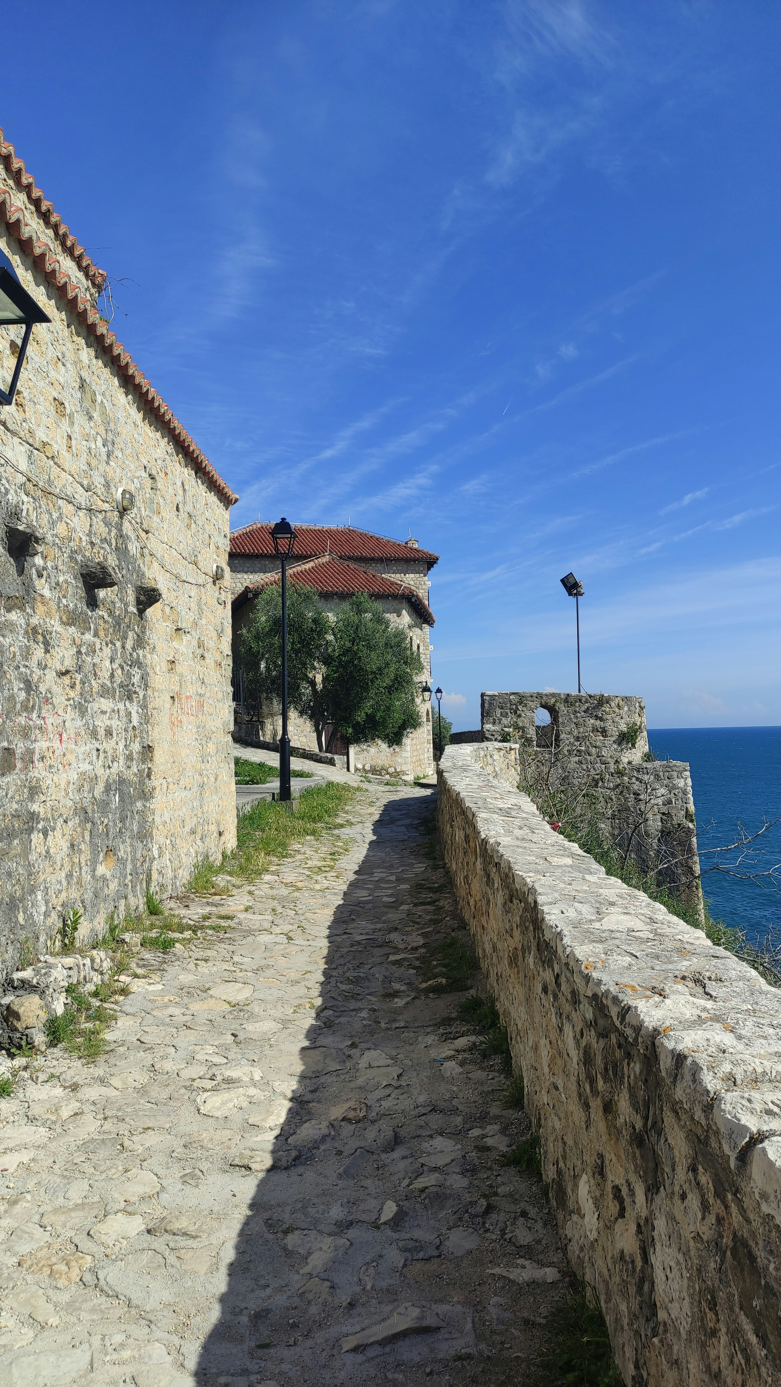海の近くにある建物の横にある石の通路