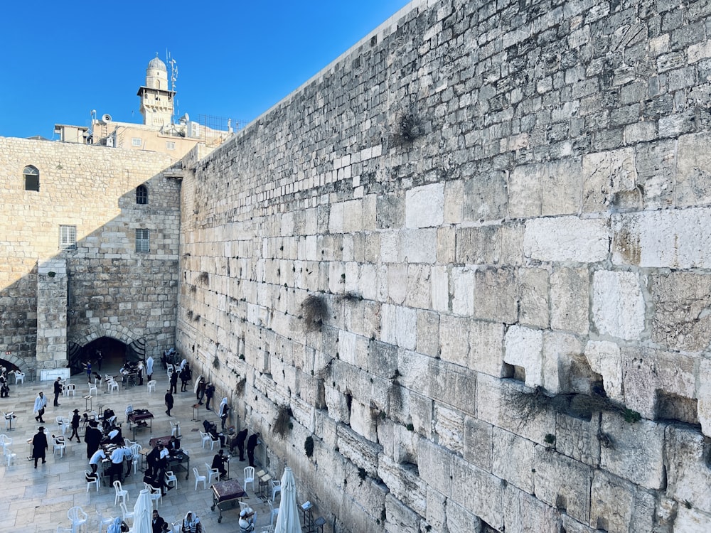 a group of people standing around a stone wall