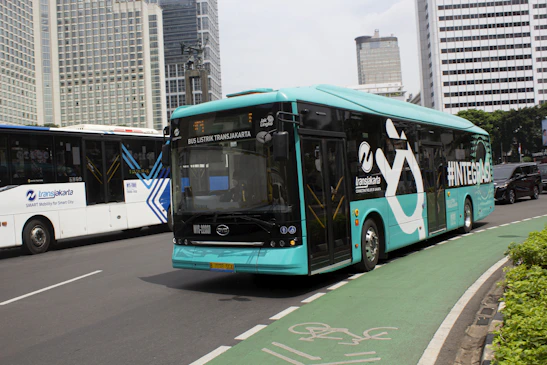 A comfortable travel van parked in front of a modern cityscape representing Jakarta.