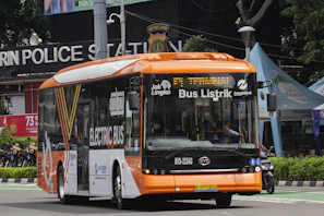Electric school bus on a sunny Lagos street, representing kabu’s eco-friendly service.