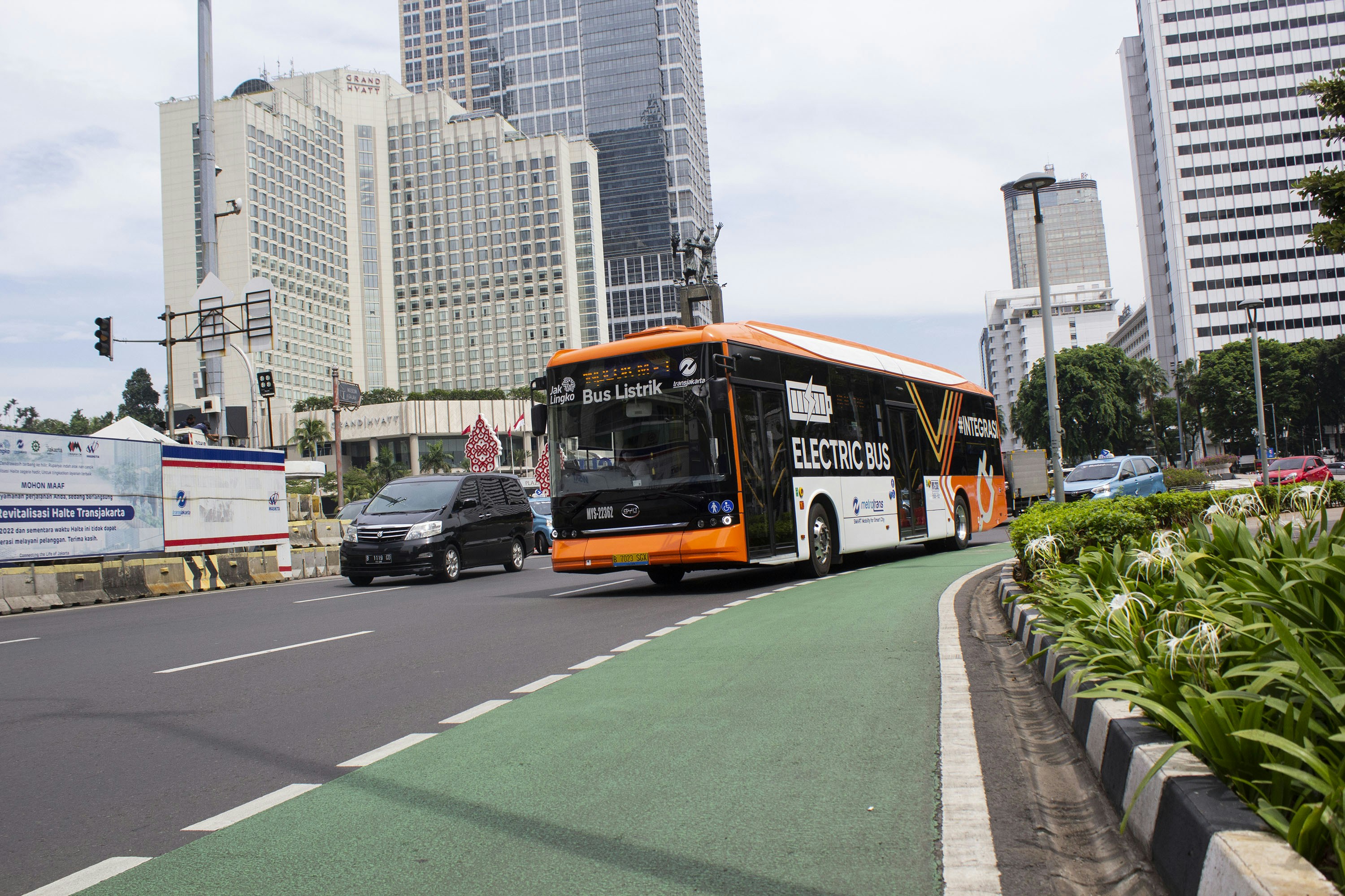 Modern white electric city bus on urban street, clean exterior, city backdrop, daylight