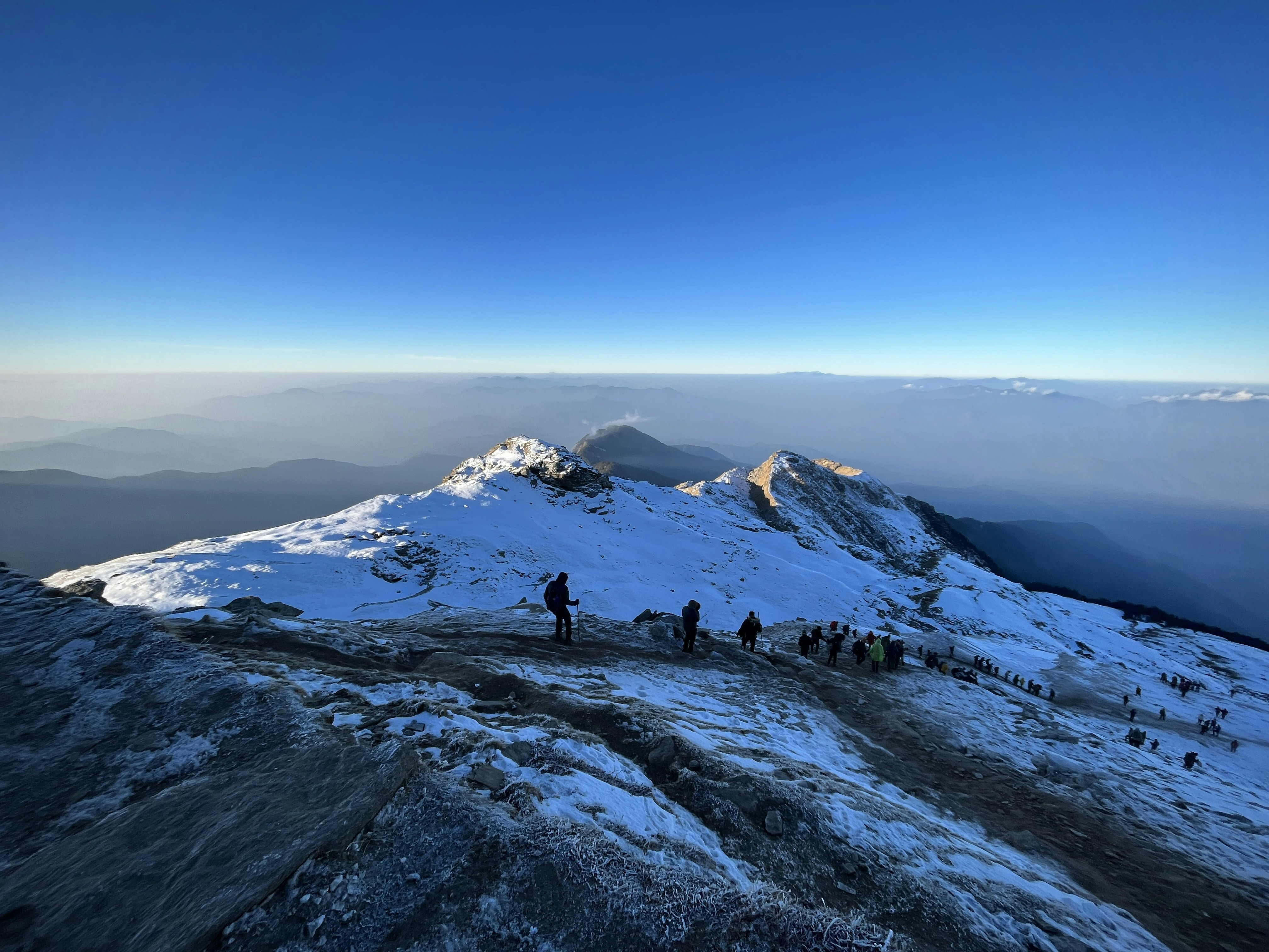 a group of people standing on top of a snow covered mountain