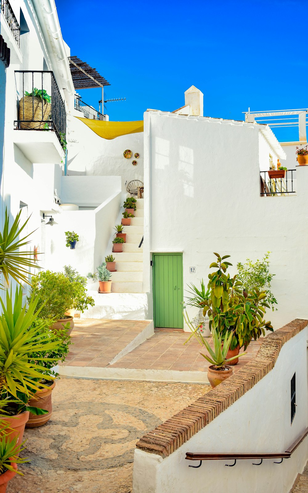 a white building with a green door and stairs