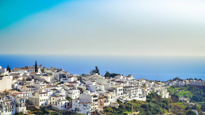 A serene coastal village with turquoise waters and whitewashed buildings.