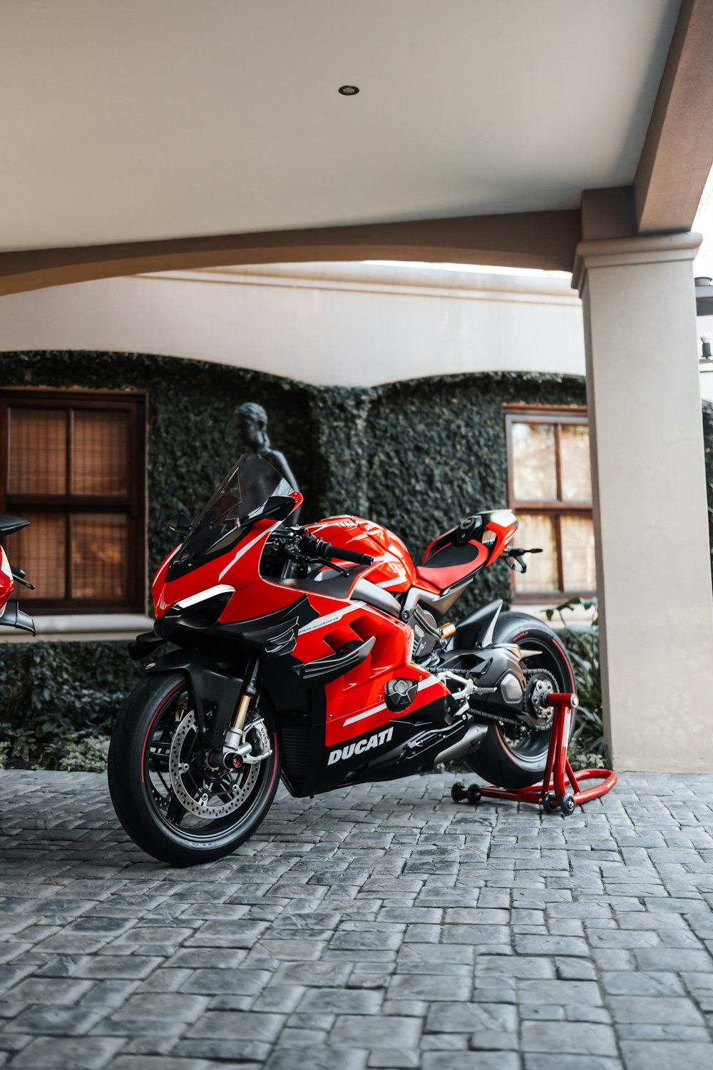 a red motorcycle parked in front of a building