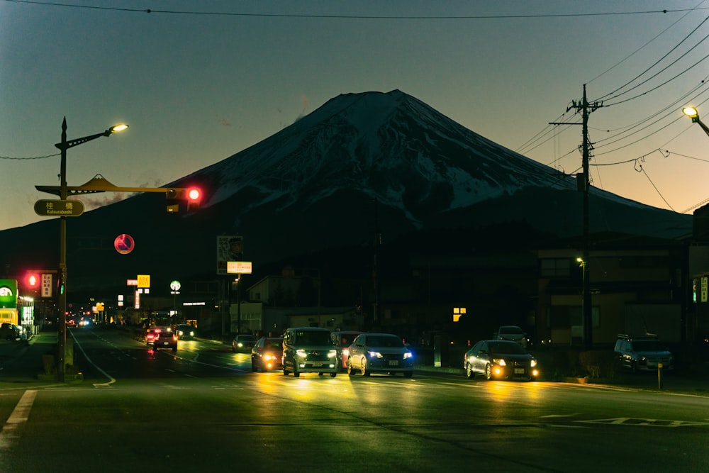 a city street at night with a mountain in the background