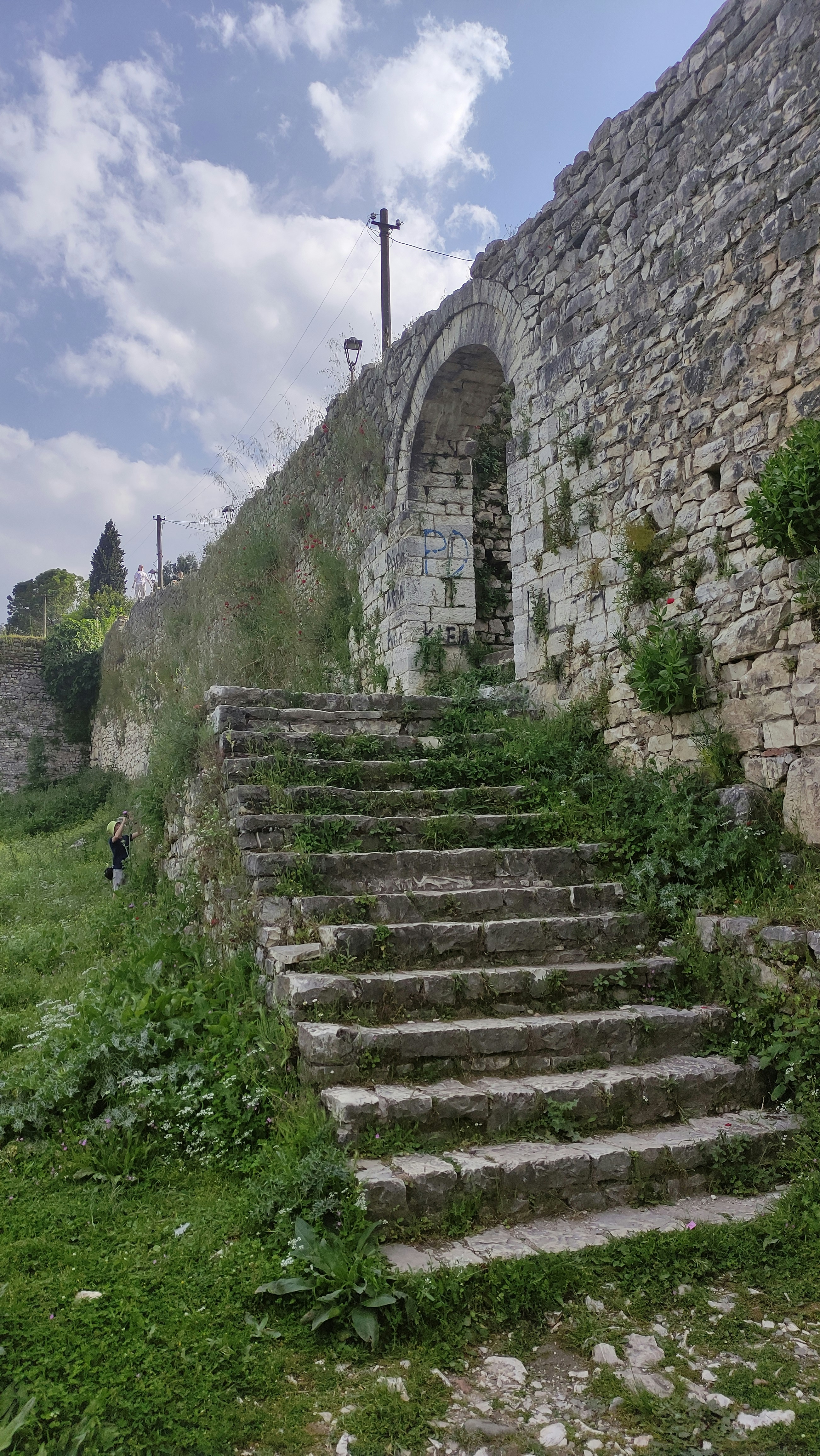 A set of stone steps leading up to a stone wall photo – Free Street ...