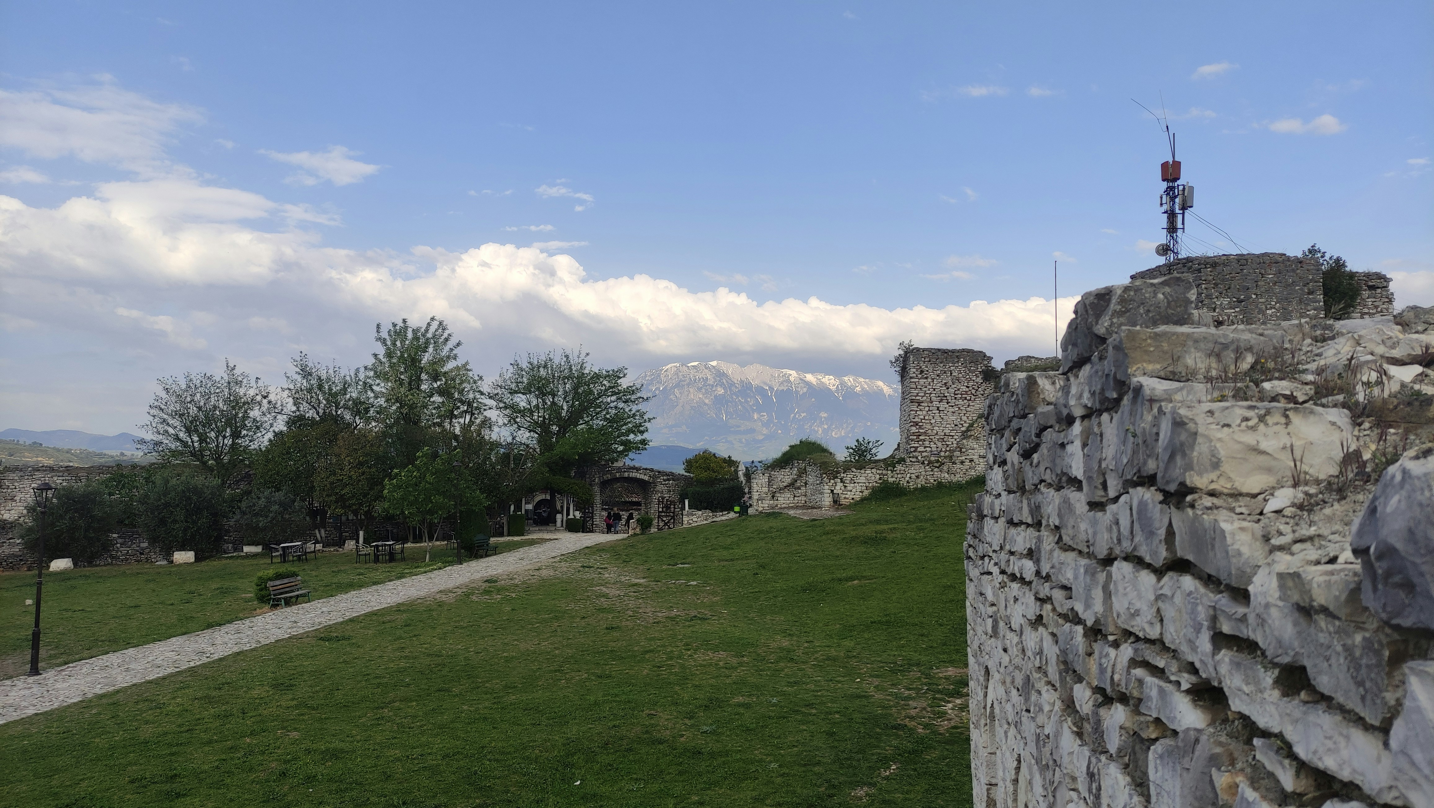 a stone wall with a grassy field in the background