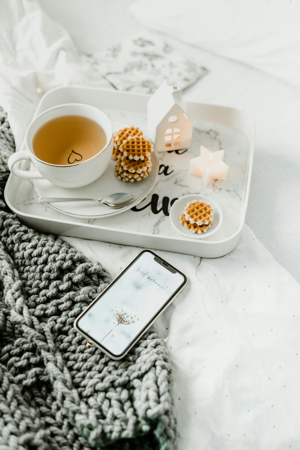 a cup of tea and a cell phone on a tray