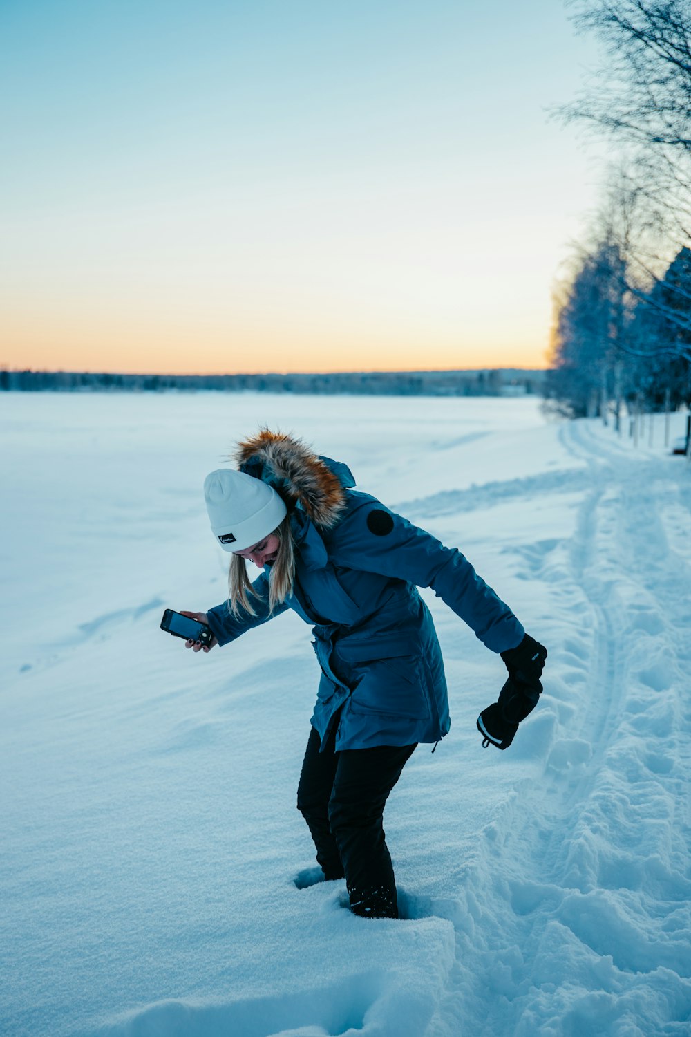 a woman in a blue jacket is snowboarding in the snow